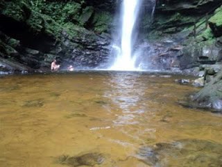 Benjamin and Mikis swimming at the pool while the waterfall sprays them with wet wind